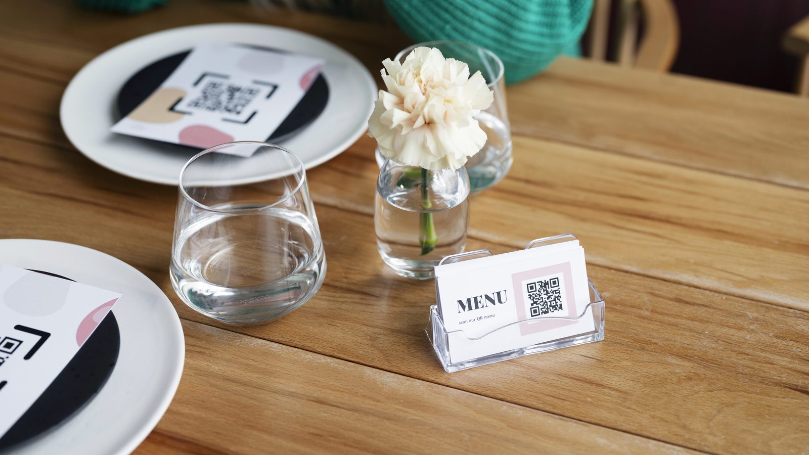 Vista aérea de um código QR pousado sobre a mesa de um restaurante, pronto a ser lido pelos clientes.